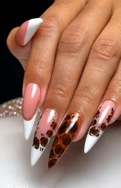Uñas stiletto con diseño de leopardo y puntas blancas.