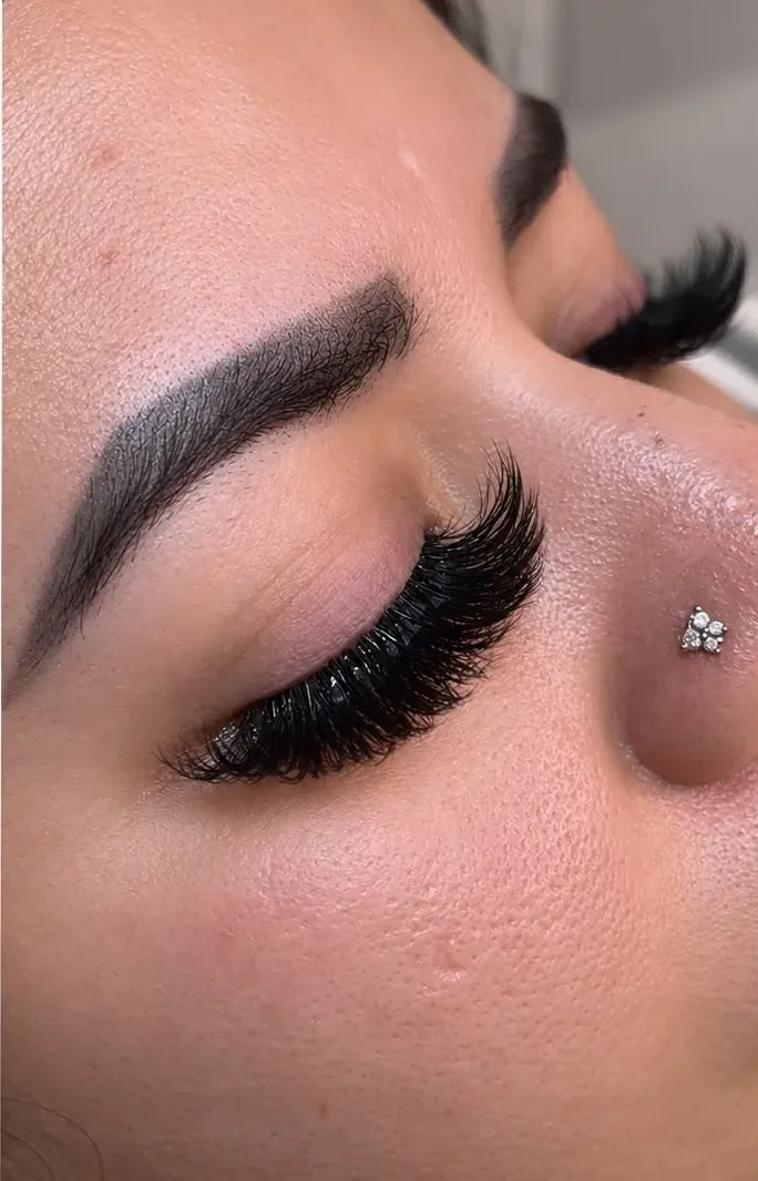 Cejas definidas y pestañas con volumen de perfil.