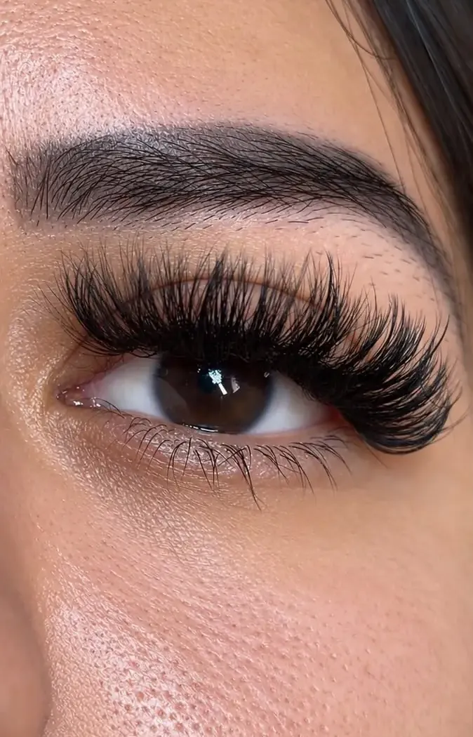 Extensiones de pestañas con volumen sobre un ojo marrón.